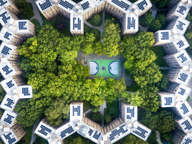 Queens bridge Houses basketball court surrounded by trees and rooftops from the sky